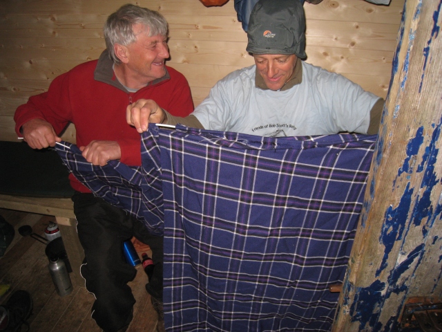Dod Thompson and Ian Shand prepare the curtains for the renovated Hutchison Memorial Hut in the Cairngorms